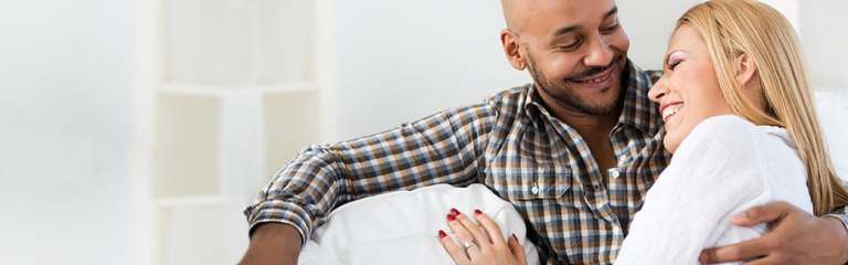 couple sitting on couch laughing together