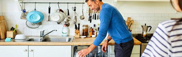 husband putting dishes in dishwasher