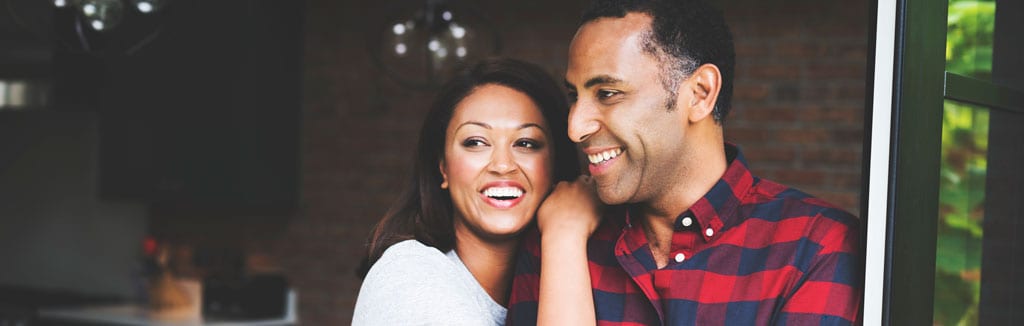 wife on her husbands shoulder, smiling